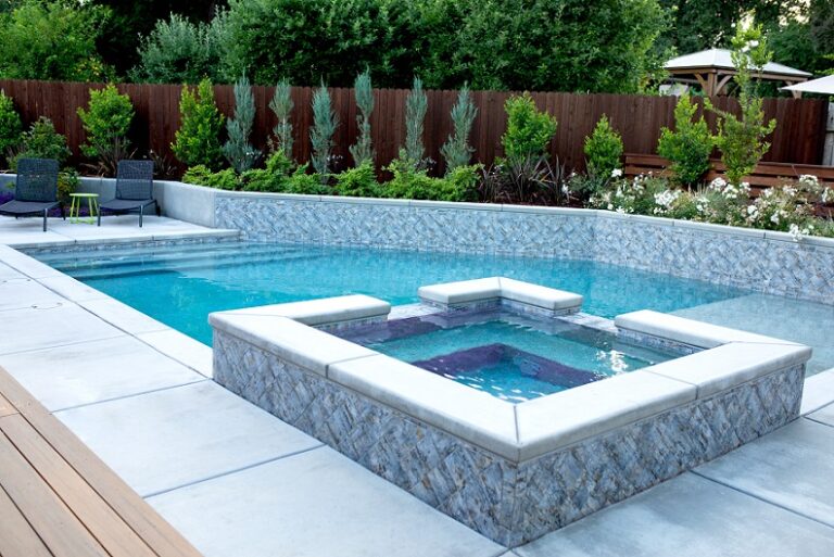 Custom shaped pool with raised spa and retaining wall for planters