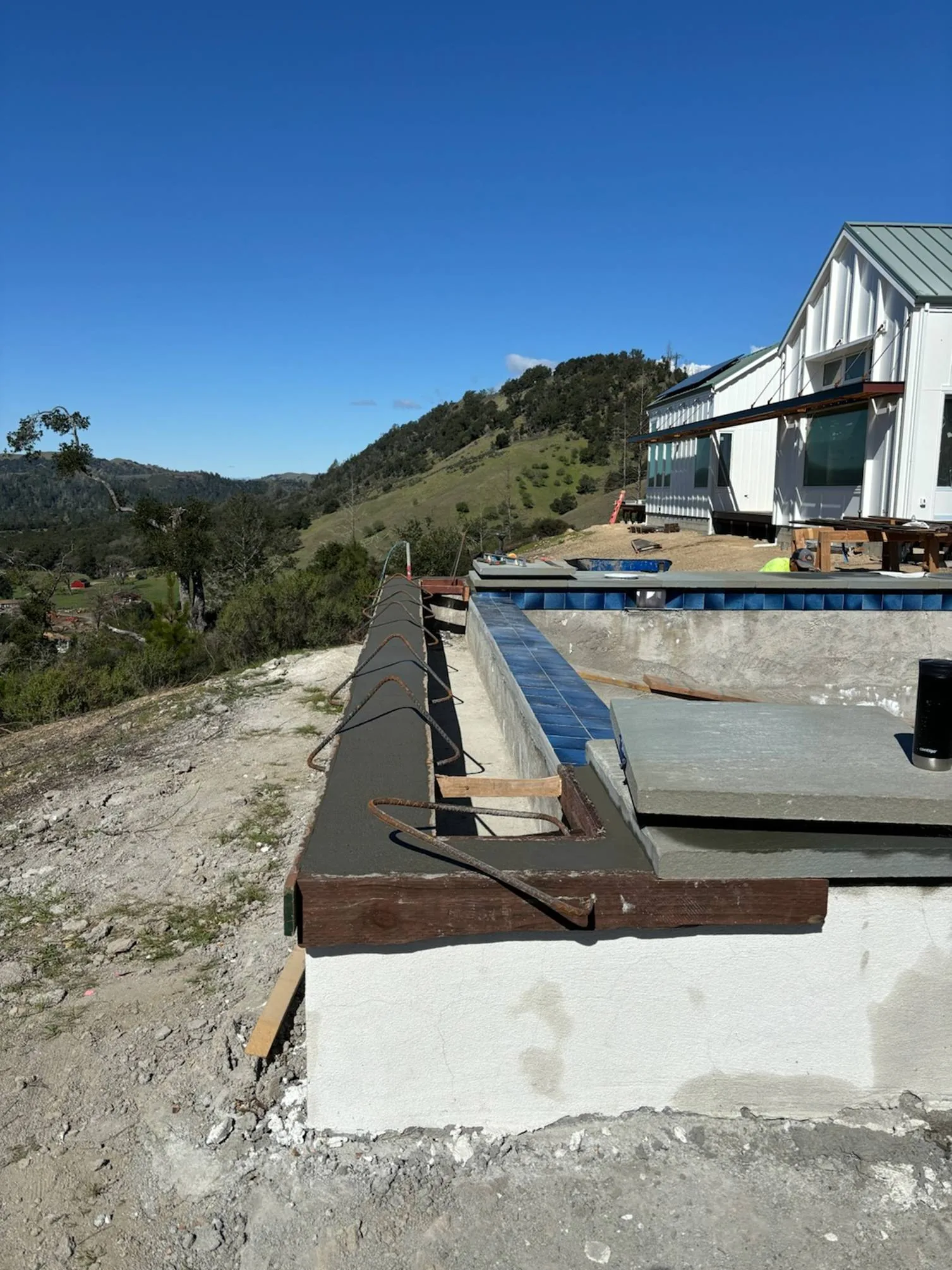 Custom-cut bluestone coping and pool-cover vault preparation on the raised Calistoga pool