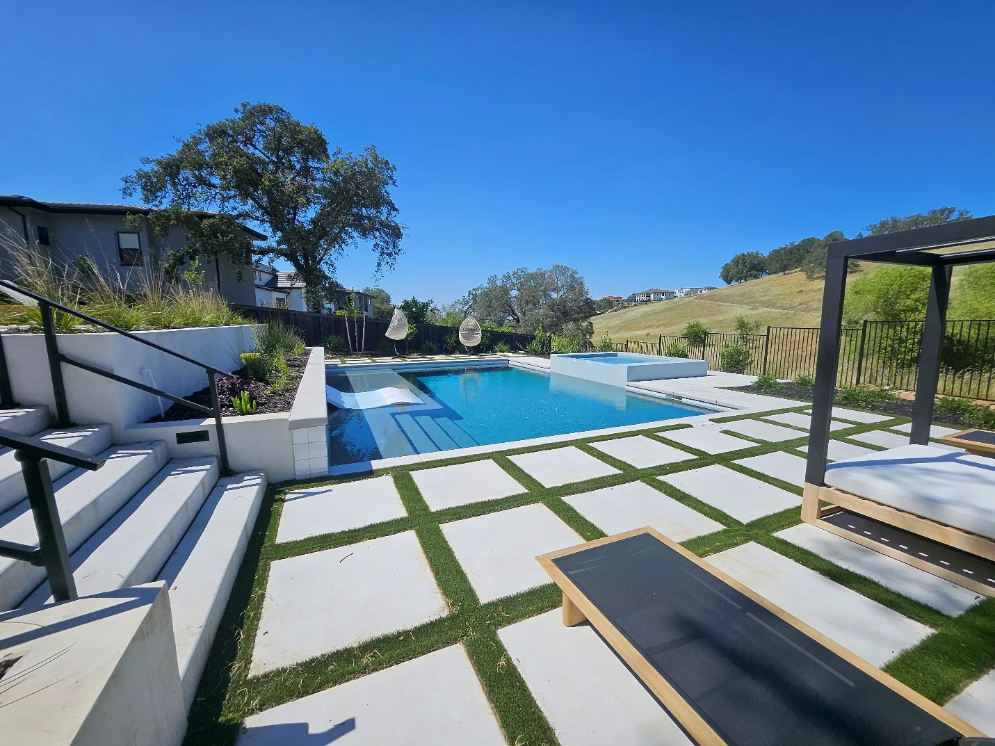Finished custom pool and spa built into a sloped backyard