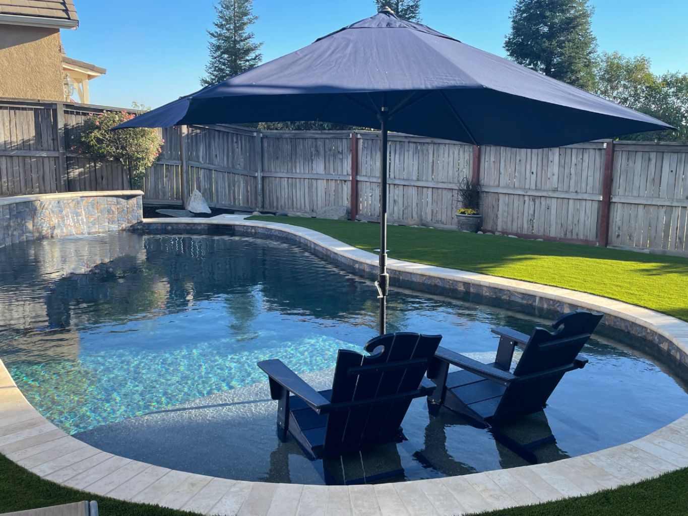 Freeform shaped pool approx. 360 square feet with raised wall with sheer descent water feature and a Cabo shelf.