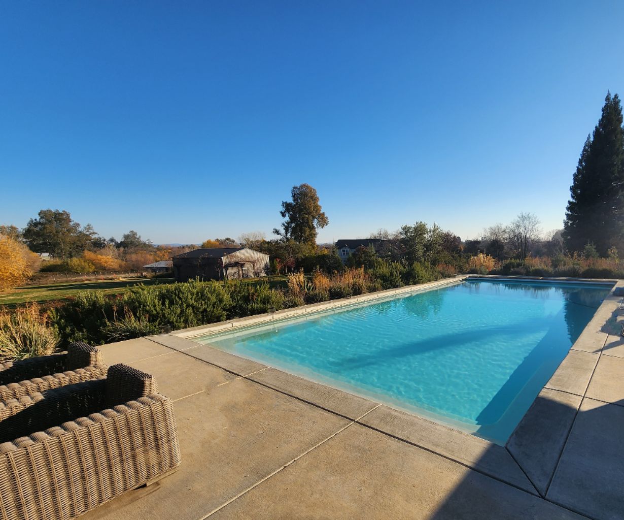 Rectangular shaped pool with automatic pool cover and concrete coping and decking